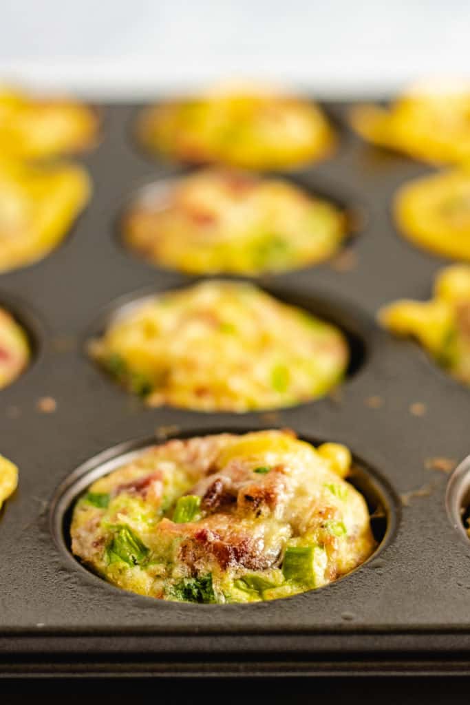 Bacon egg muffins in a muffin pan.