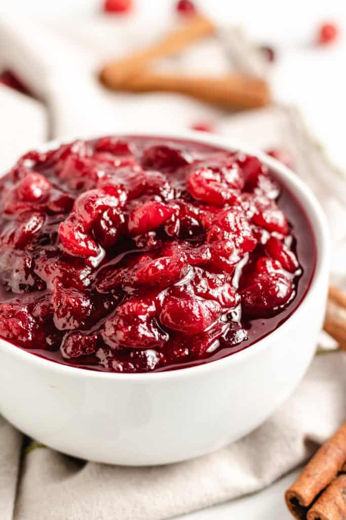 Close up view of homemade cranberry sauce in a white bowl.