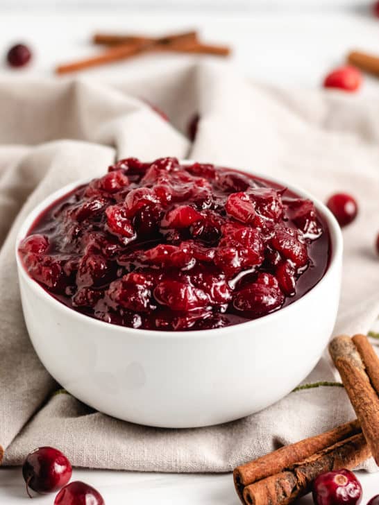 Cinnamon sticks with cranberry sauce in a bowl.