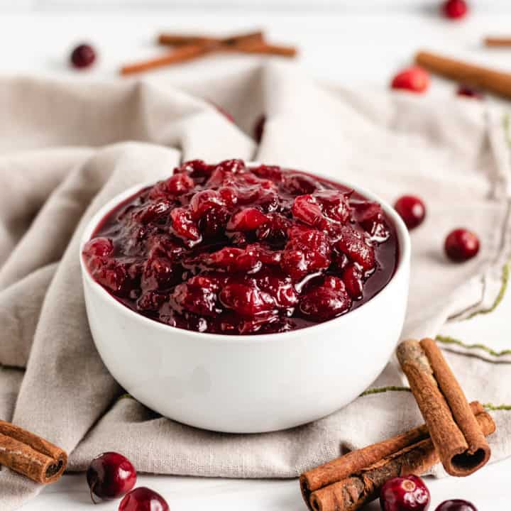 Cinnamon sticks with cranberry sauce in a bowl.