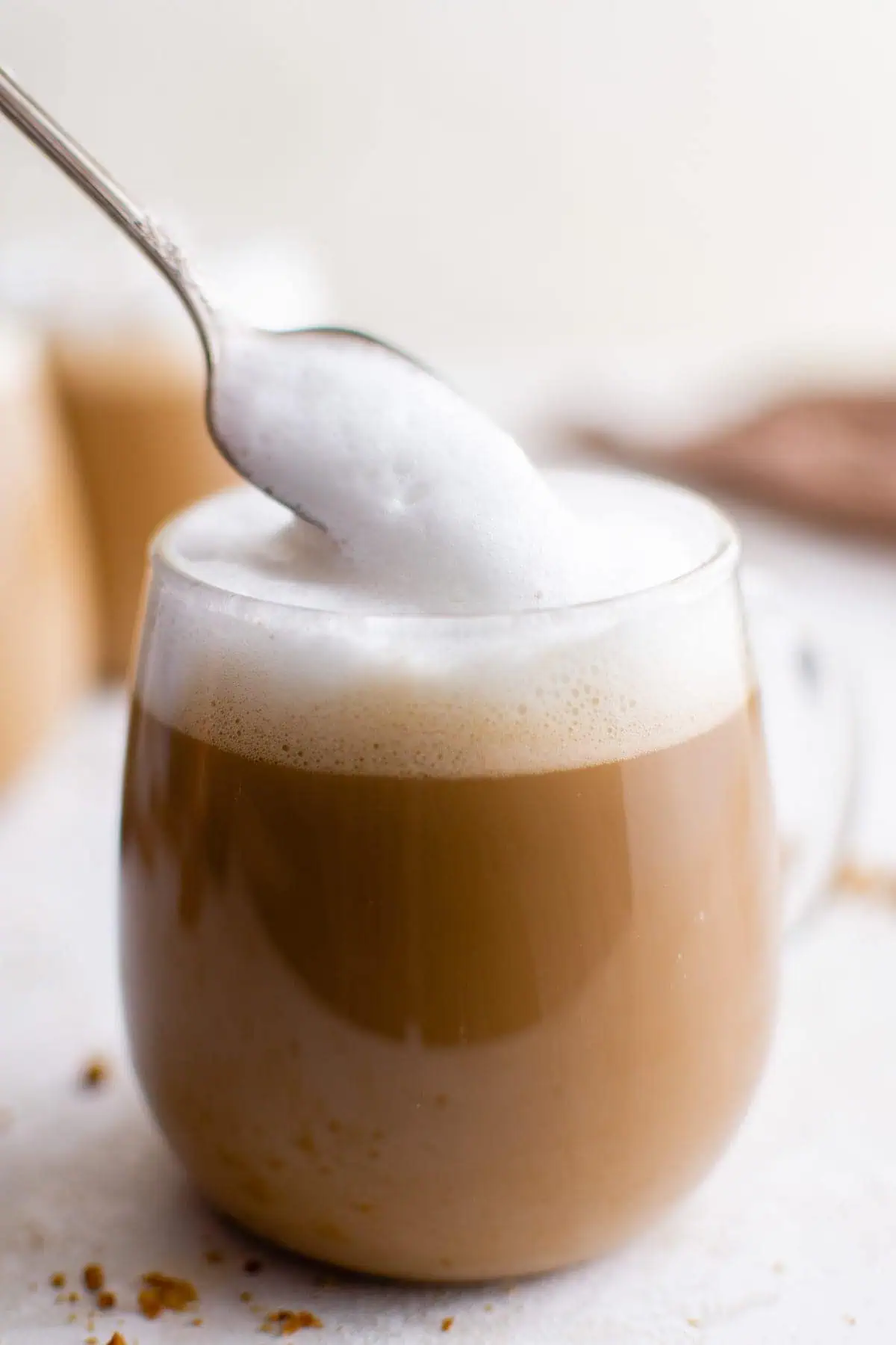 Foamed milk being spooned onto gingerbread latte.