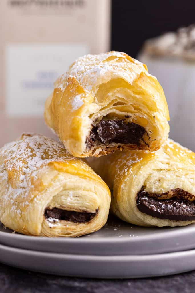 Three chocolate filled pastries in a stack.