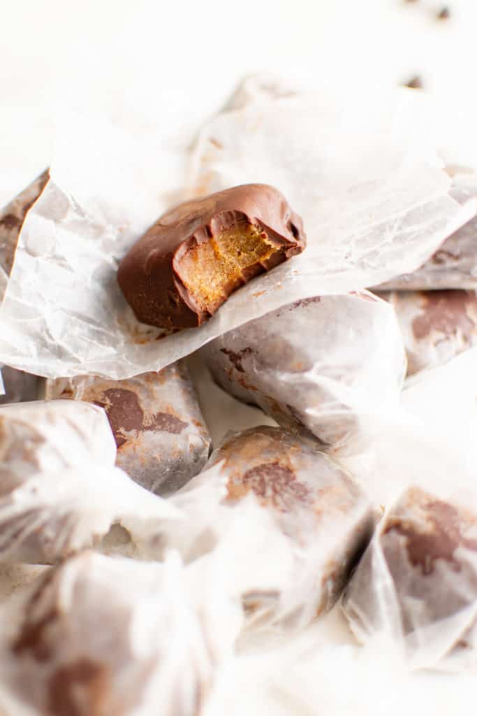 Chocolate covered date caramel sitting on wax paper.