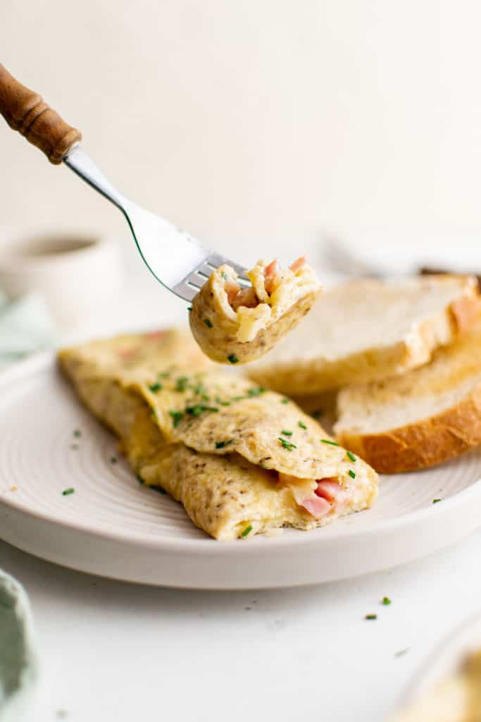 Fork holding a bite of omelette.