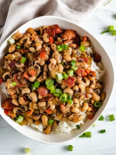 Top down view of Hoppin john in a white bowl.
