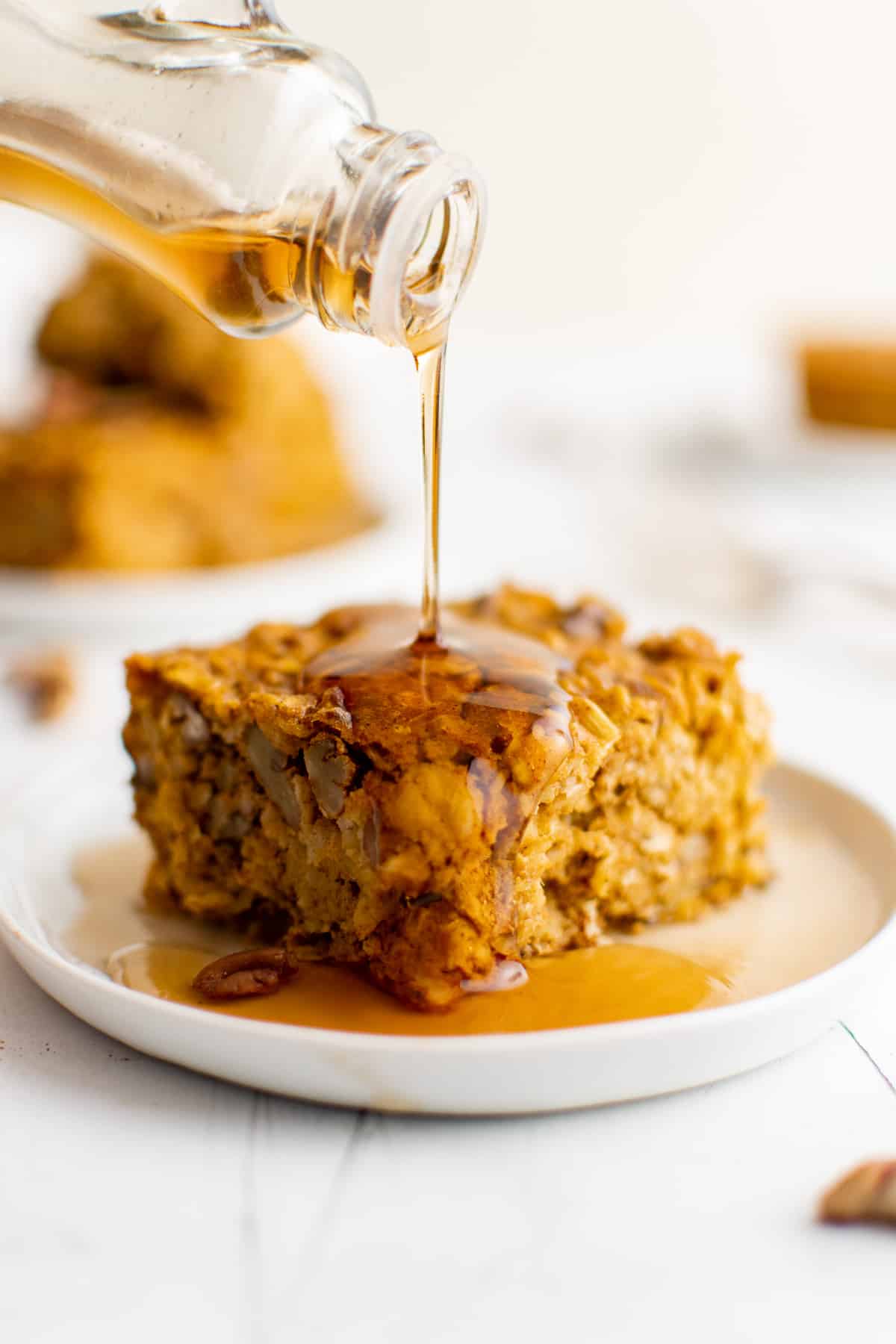 Syrup being poured over pumpkin baked oatmeal.