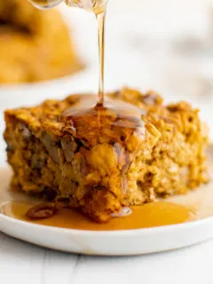 Maple syrup being drizzled on pumpkin baked oatmeal.