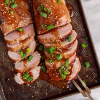 Top down view of a serving fork with teriyaki pork tenderloin.