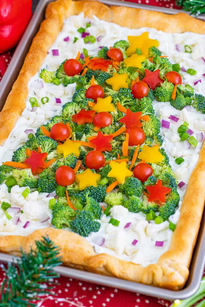 Top down view of a crescent roll veggie pizza on a sheet pan.