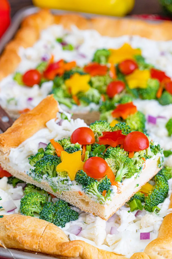 Fresh veggies on a slice of pizza.