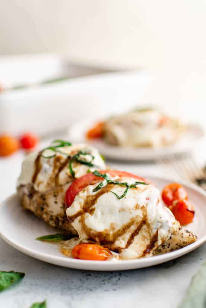 Baked chicken caprese on a white plate.