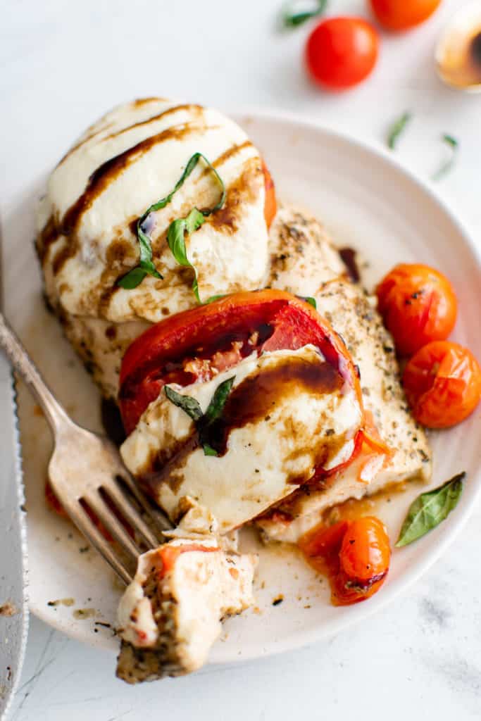 Top down view of baked caprese chicken on a plate.
