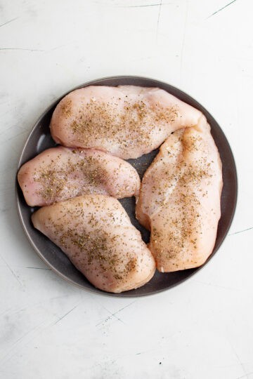Seasonings sprinkled on chicken.