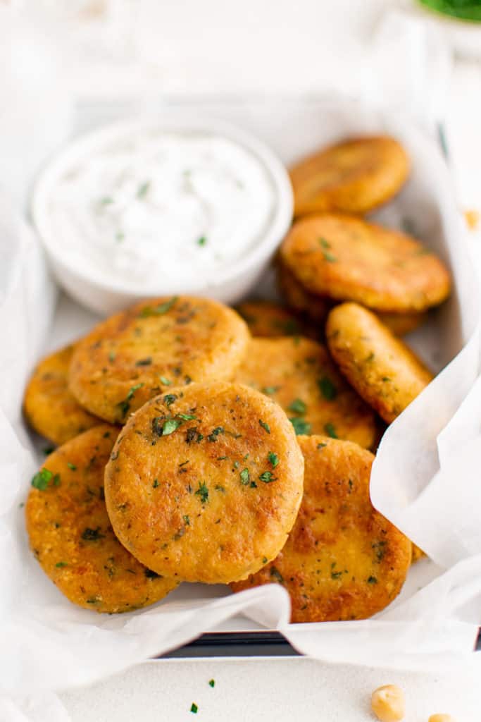 Batch of chickpea fritters and dip on a platter.