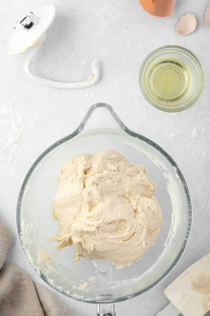 Bread dough mixed in a glass mixing bowl.