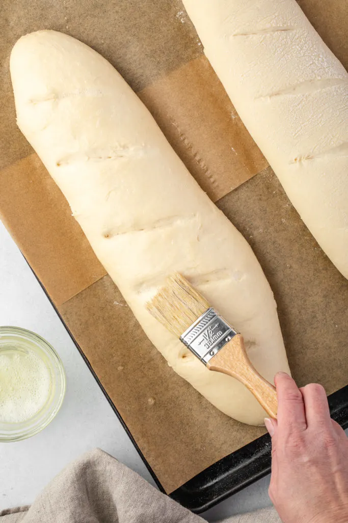 Egg wash being applied to bread.