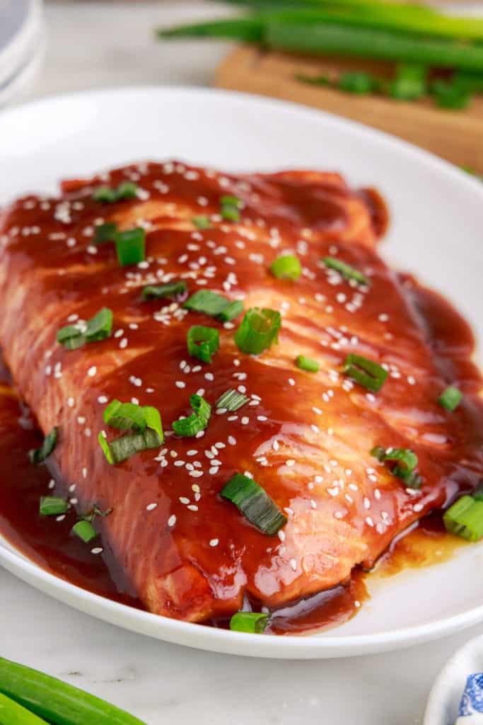 Teriyaki salmon on a white serving dish.