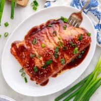 Top down view of teriyaki salmon on a platter.
