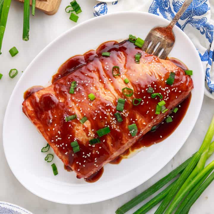 Top down view of teriyaki salmon on a platter.