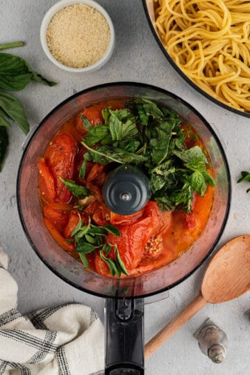 Roasted tomatoes and basil in a food processor.