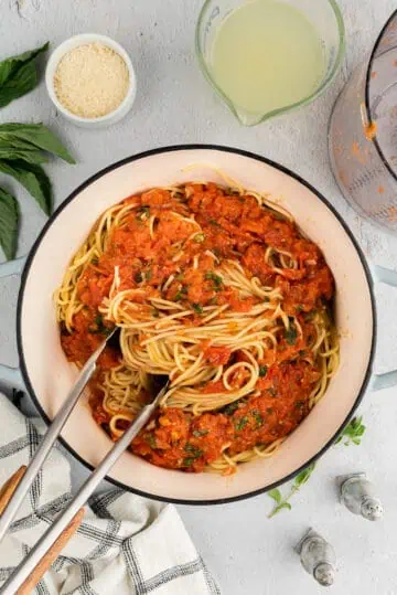 Pasta noodles being twirled with fresh tomato sauce.