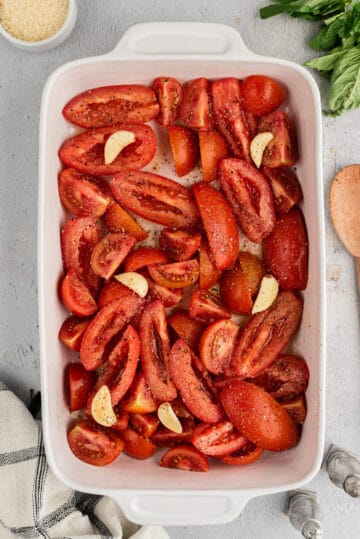 Fresh tomatoes, garlic, olive oil, salt and pepper in a baking dish.