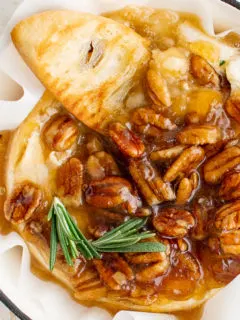 Top down view of fresh rosemary on baked brie.