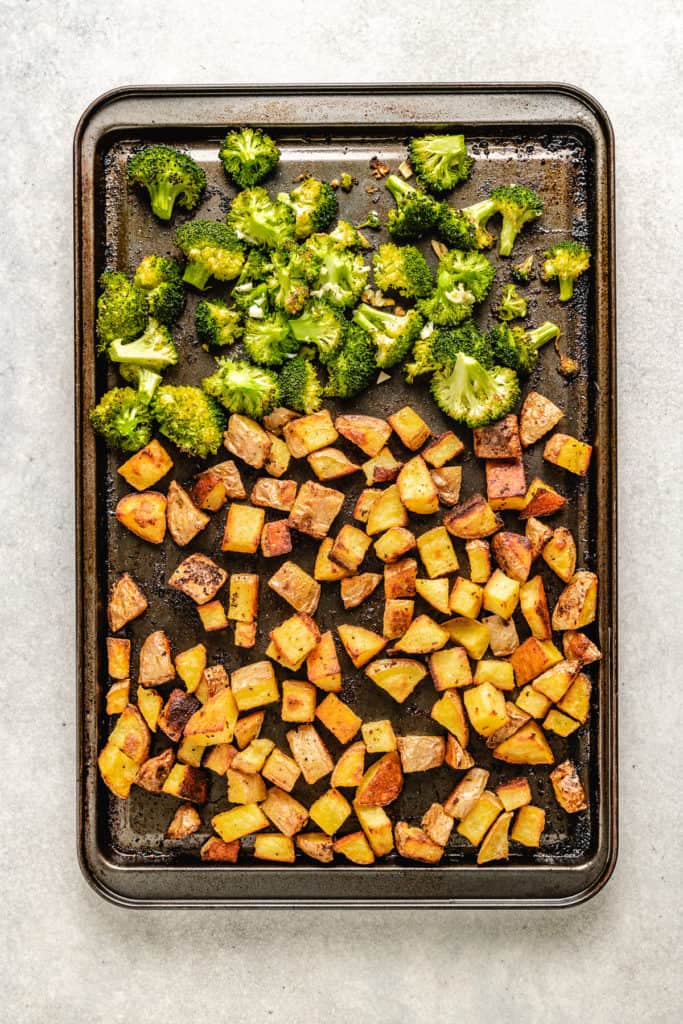 Roasted potatoes and broccoli on a pan.
