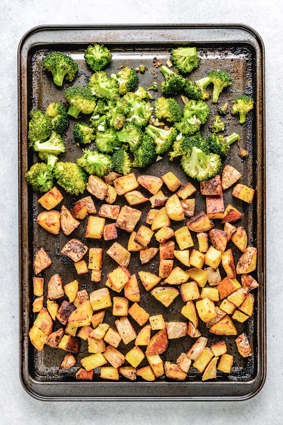 Roasted potatoes and broccoli on a pan.