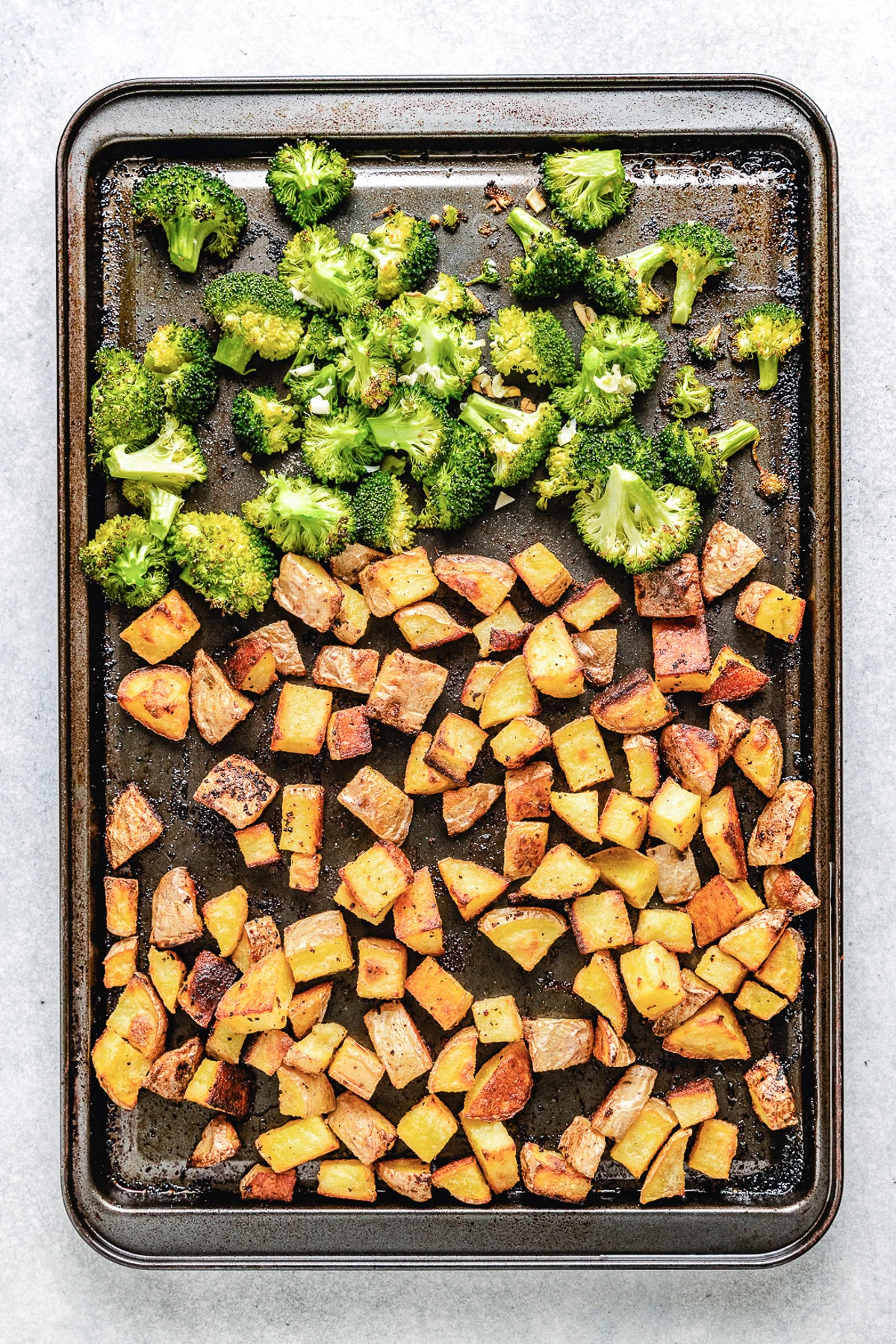 Roasted potatoes and broccoli on a pan.
