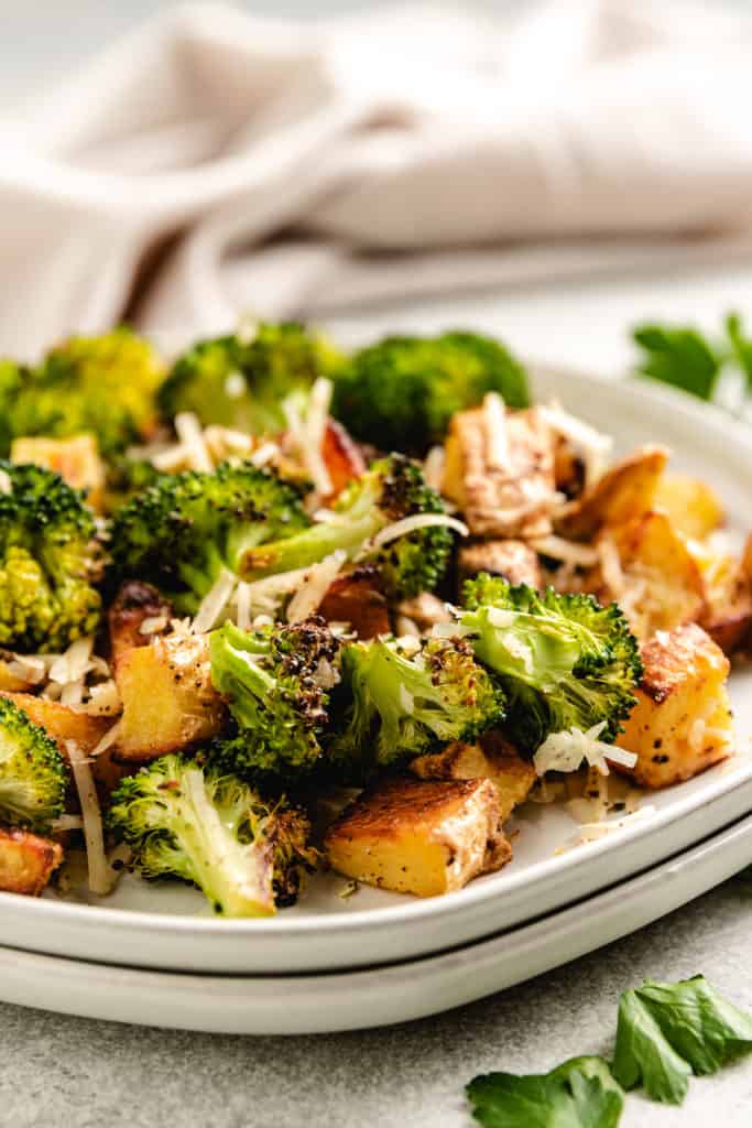 Close up view of a plate of roasted potatoes and broccoli.
