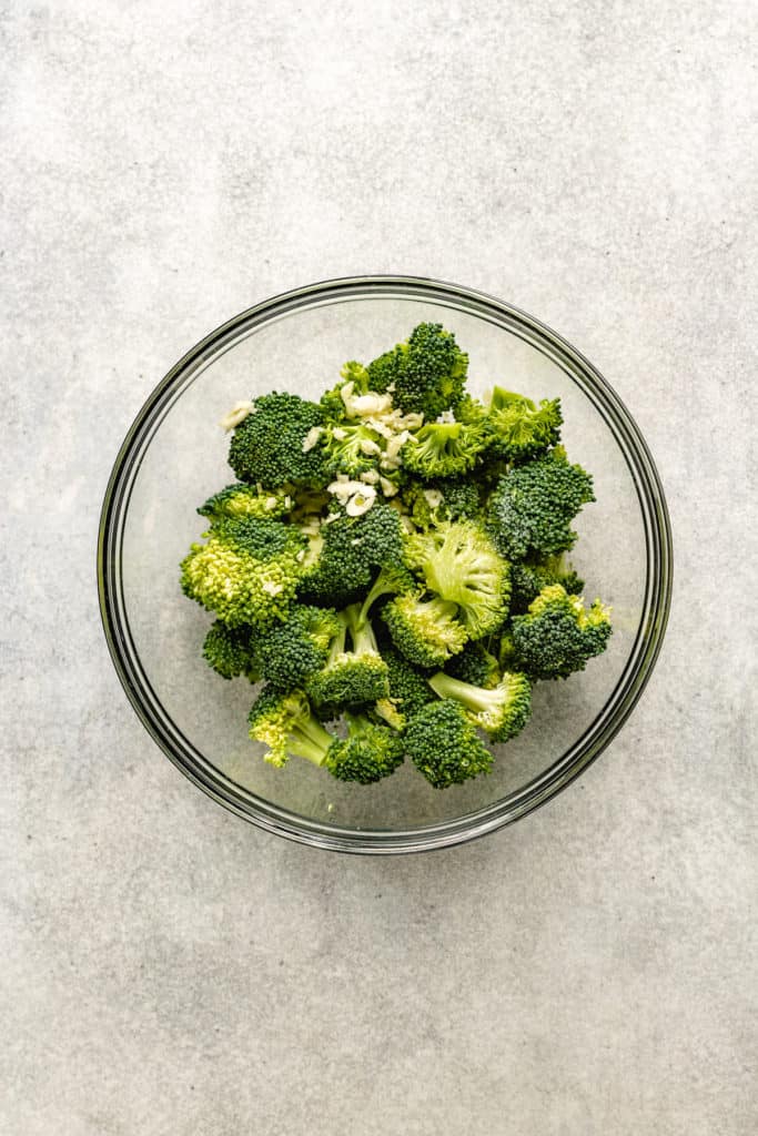 Garlic on top of broccoli in a bowl.