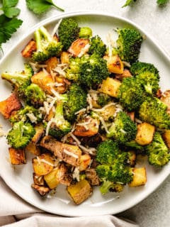 Roasted broccoli and potatoes on a small plate.