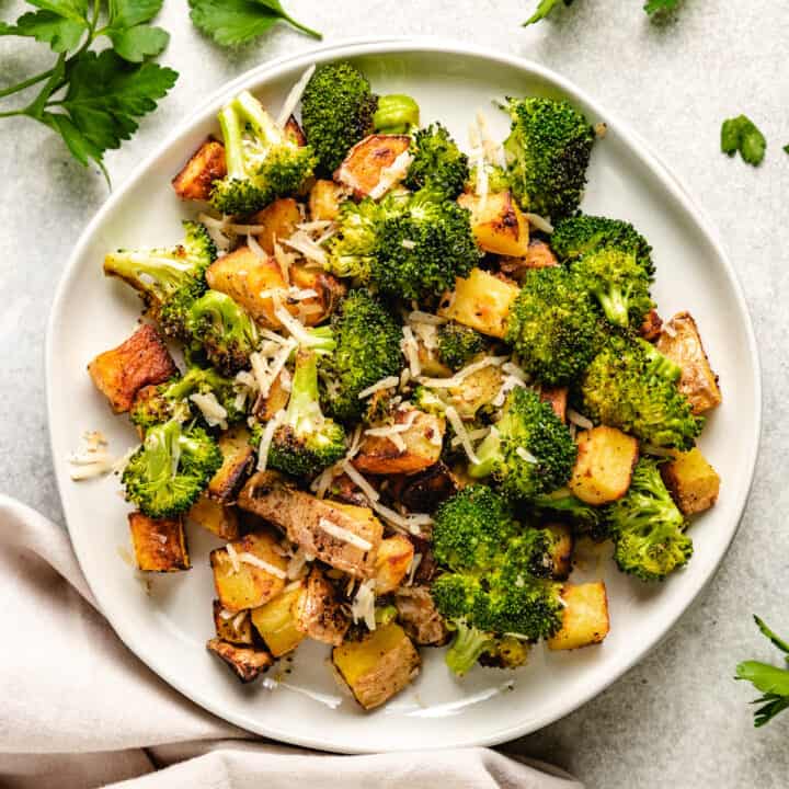 Roasted broccoli and potatoes on a small plate.
