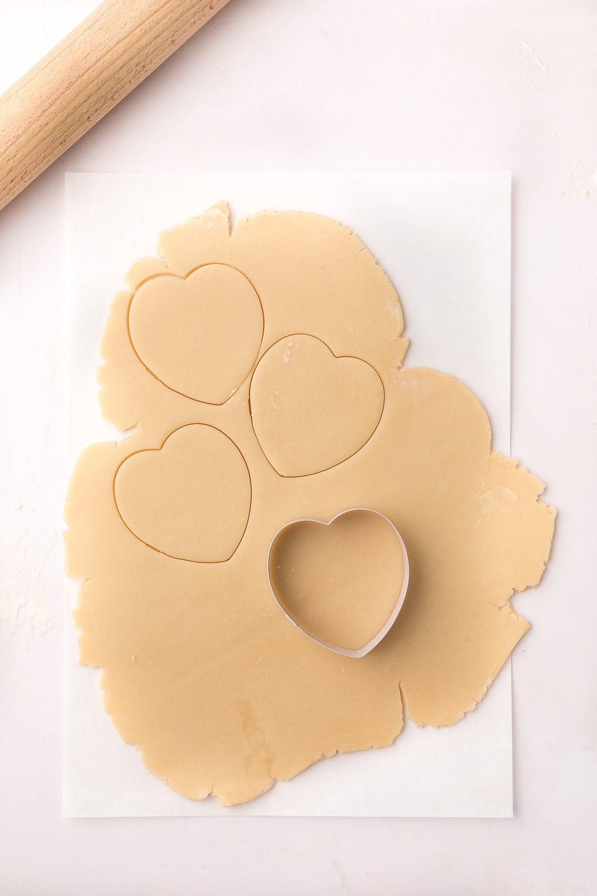 Heart shaped metal cookie cutter on dough.