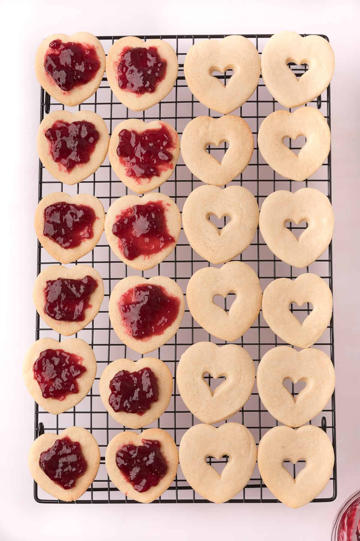 Sandwich cookies being filled with jam.