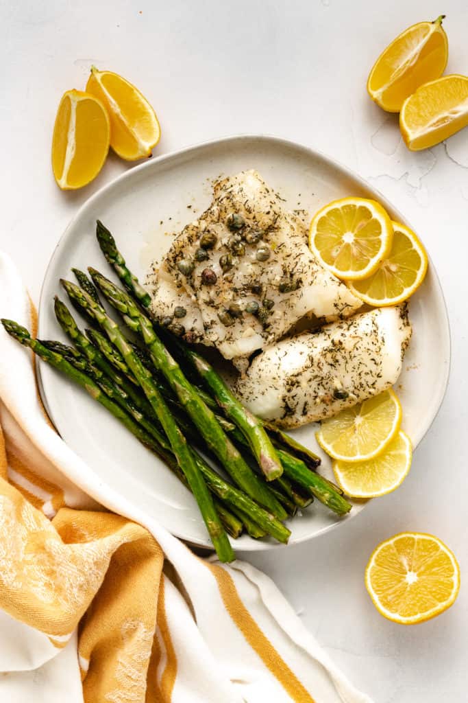 Top down view of sea bass and asparagus on a plate.
