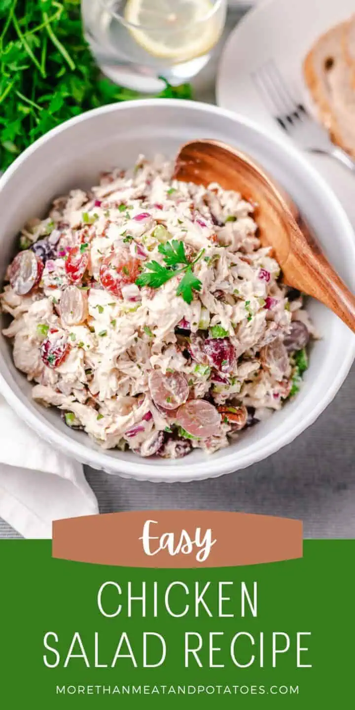 White bowl filled with a chicken salad recipe and a wooden spoon.