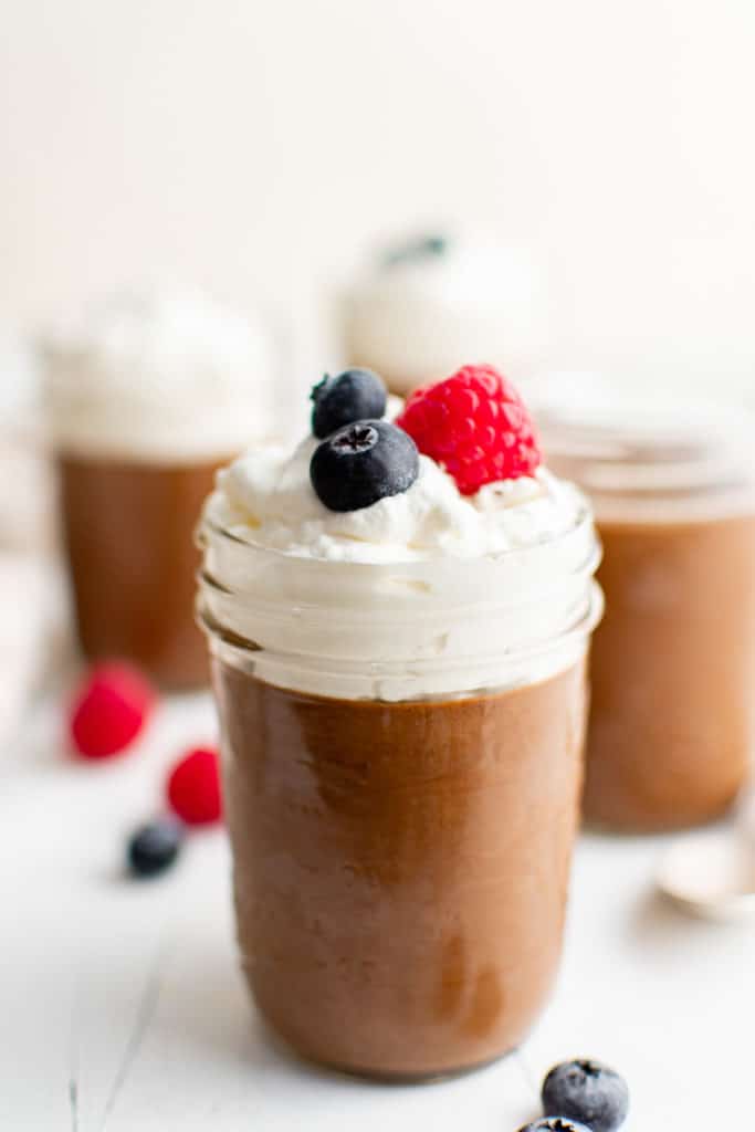Jar of chocolate mousse with fresh berries.