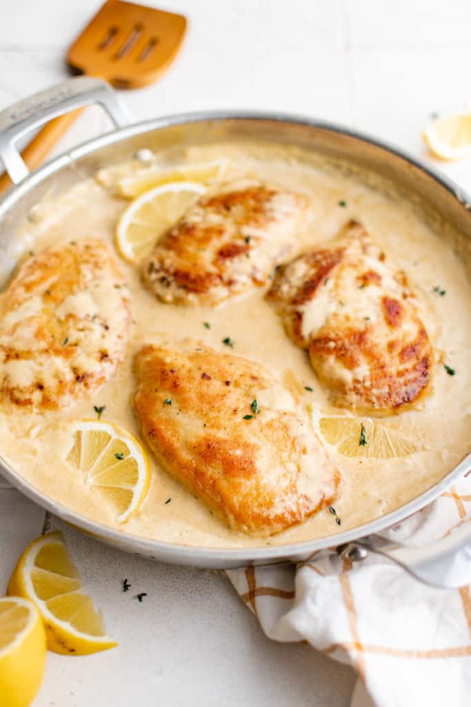 Side view of creamy lemon chicken in a pan.