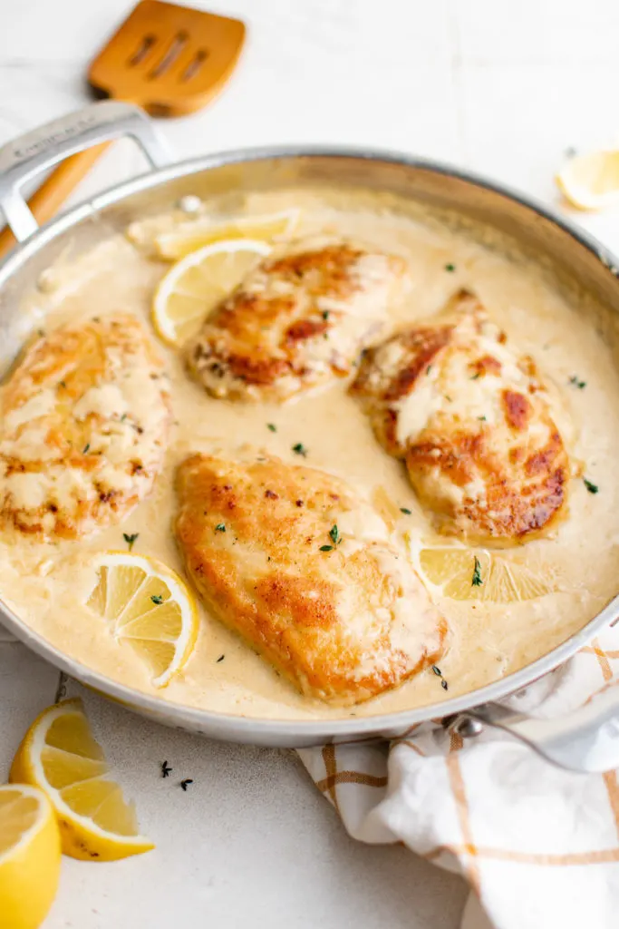 Side view of creamy lemon chicken in a pan.