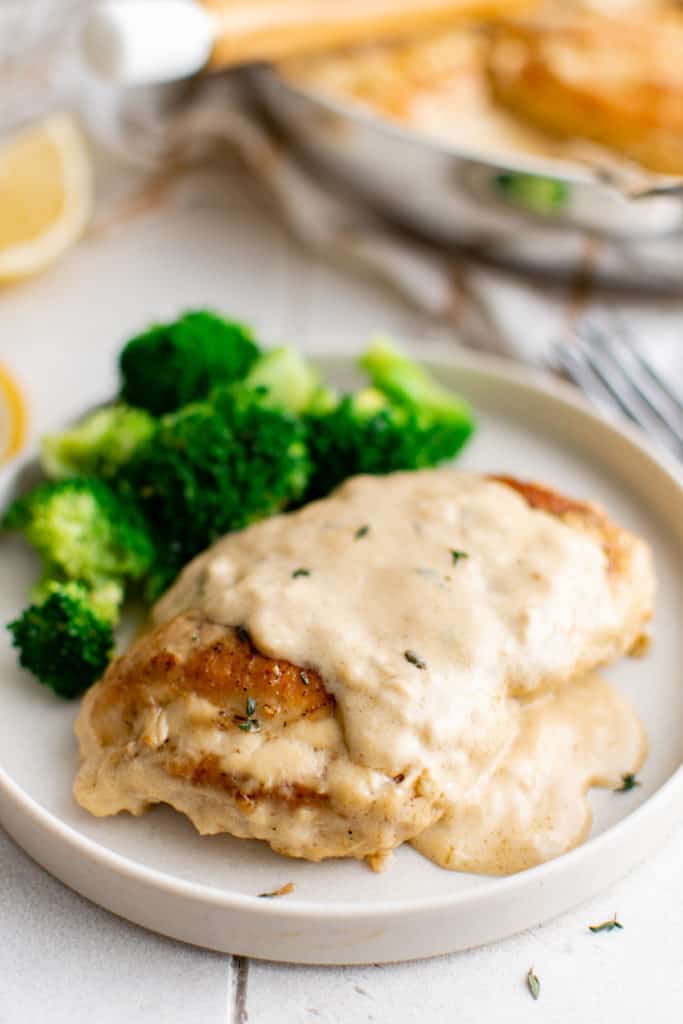 Chicken with lemon sauce on a white plate.