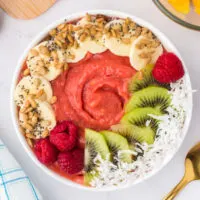 Fruits and seeds on top of a smoothie bowl.