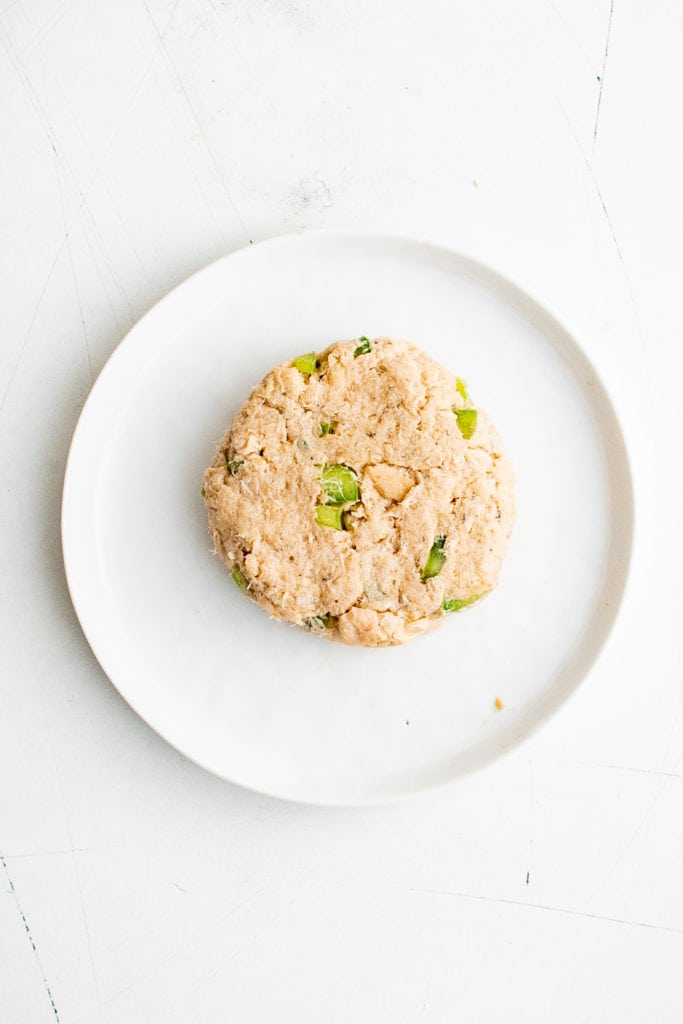 Uncooked salmon croquette on a plate.