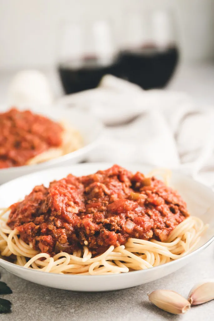 White dish piled with spaghetti with meat sauce.