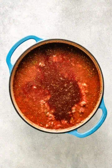 Beef broth poured into tomatoes and seasonings.