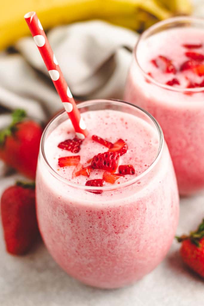 Straw in a glass of strawberry smoothies.