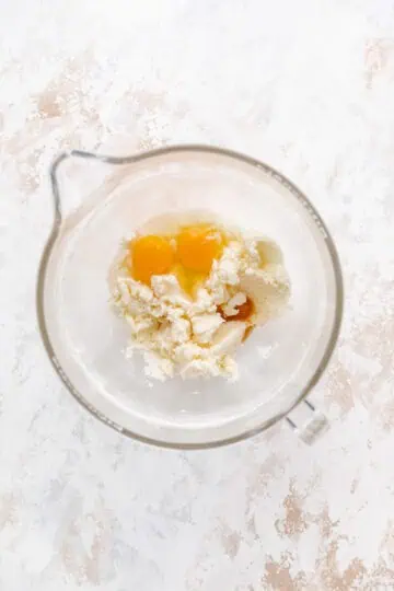 Eggs, vanilla, butter and sugar in a bowl.