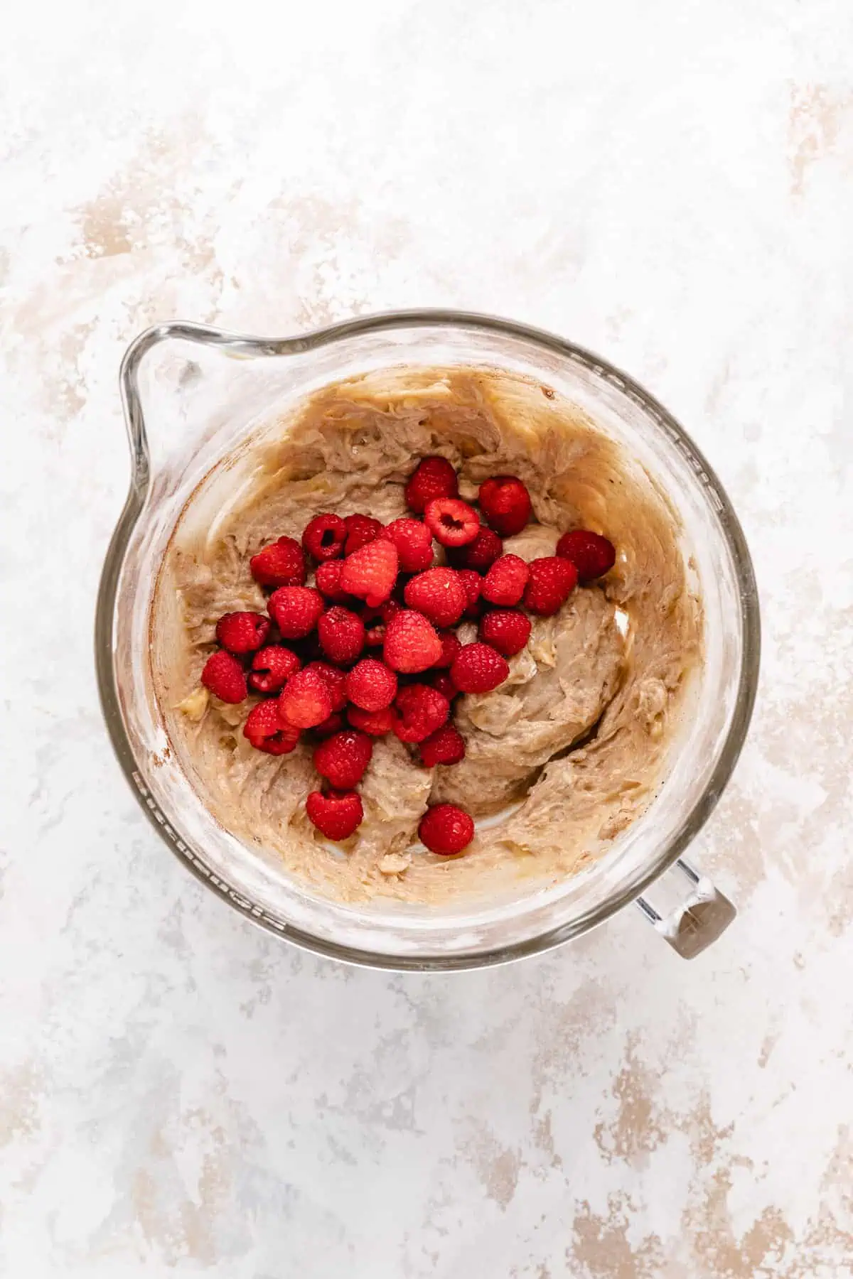 Raspberries poured over muffin batter.