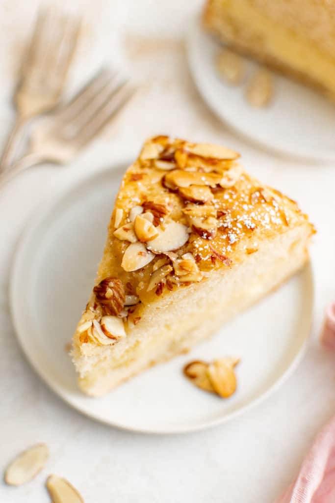 Slice of cake with almonds on a plate.